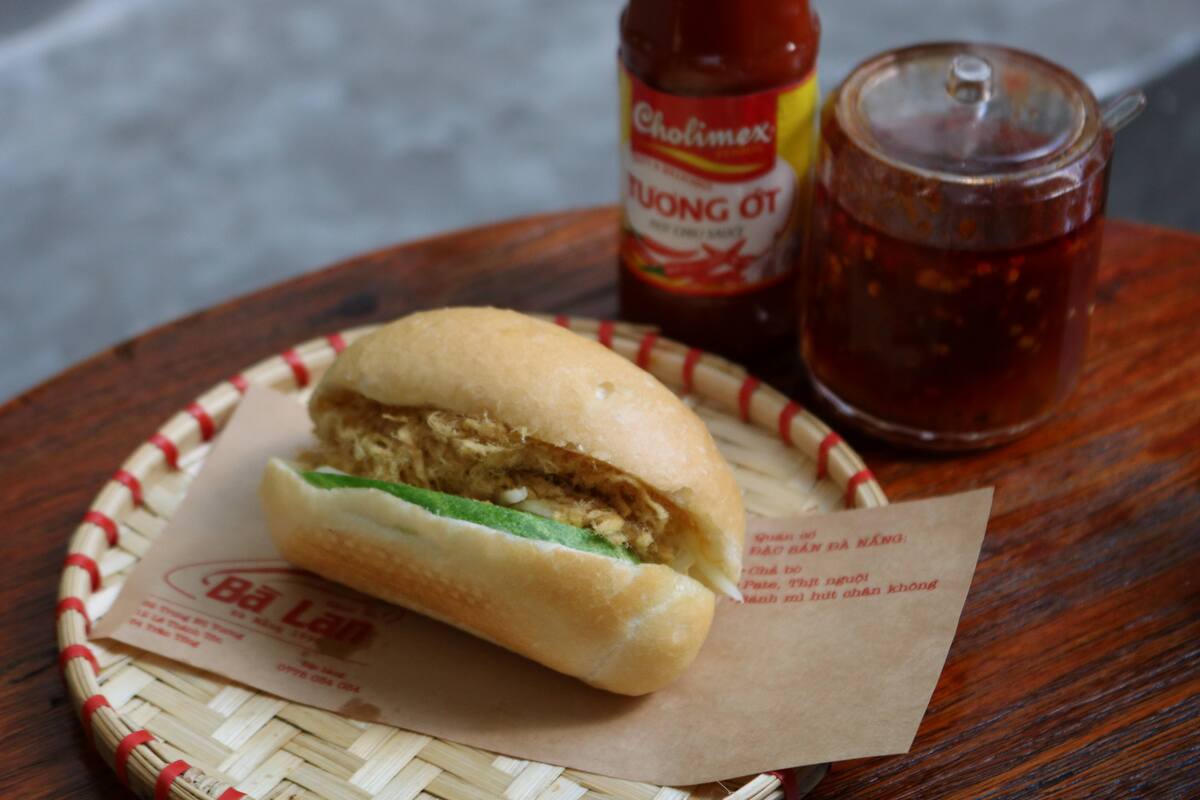 バインミーガー12,000VND(約70円) 甘めのマヨネーズと鶏肉のドライフレーク、キュウリが入ったシンプルな小さいバインミー。子ども時代を思い出す素朴な一品