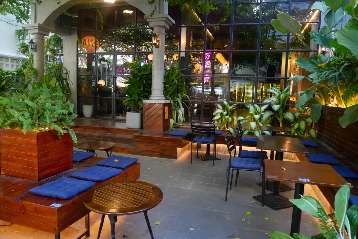 屋外の席はテーブルが７席ほどあり、緑に囲まれた空間です。