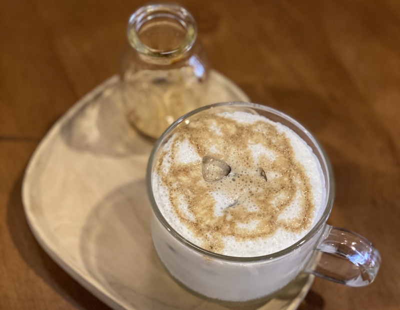 塩が含まれた白いミルクフォームに氷とコーヒーを入れます