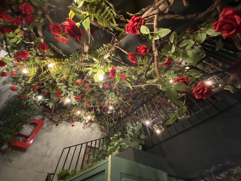 階段の上部 一階奥のエリアから二階にかけて造花の花が主に天井を這うように張り巡らされています